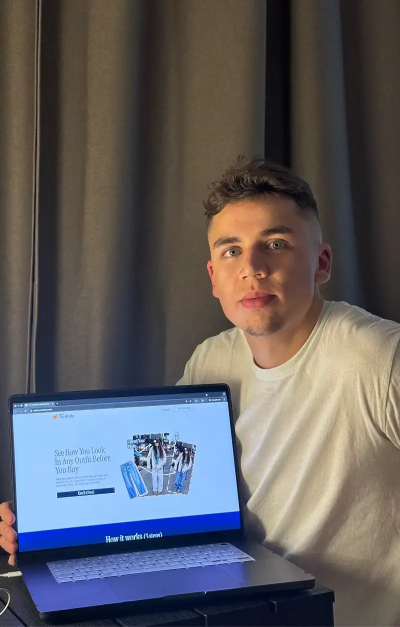 Founder of Ask My Wardrobe holding a laptop displaying the virtual try-on clothes app homepage, showing how users can upload their photo and clothing item to see how they look before buying online